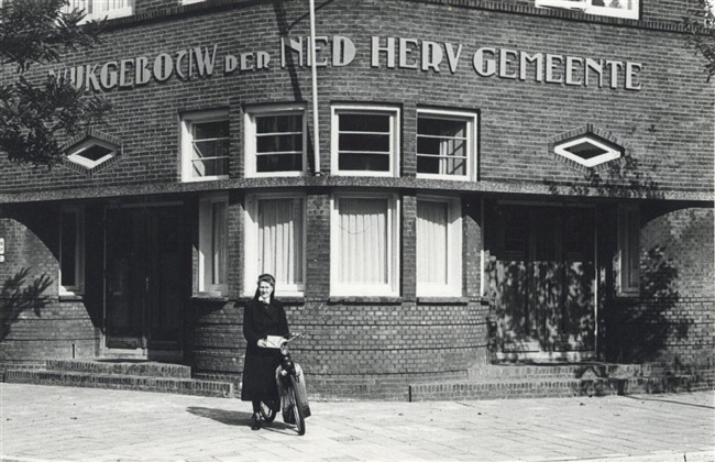 Het gebouw met wijkdiacones Truus Velthuijsen.
              <br/>
              L.H Hofland / coll. Het Utrechts Archief, 1951
